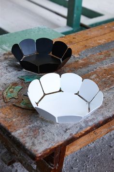 two white and black plates sitting on top of a wooden table next to each other