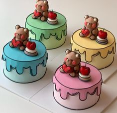 four cakes with teddy bears sitting on top of each one, all decorated in different colors