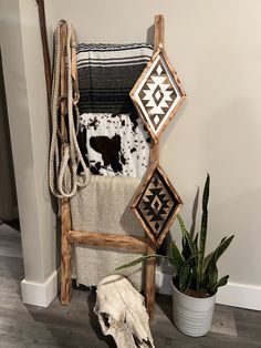 a cow skull is sitting on the floor next to a chair and towel rack with towels