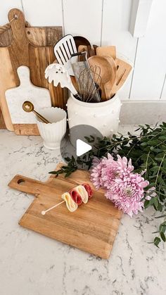 flowers and utensils are sitting on a cutting board