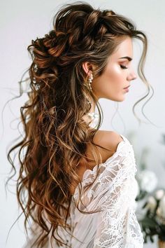 a woman with long curly hair wearing a white dress and pearls in her hair is looking off to the side