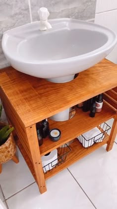 a white sink sitting on top of a wooden stand