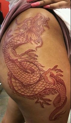 a woman with a dragon tattoo on her thigh