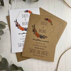 three wedding save the dates cards on top of each other with leaves and flowers around them