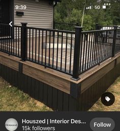 a wooden deck with black iron railings