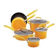 yellow pots and pans are stacked on top of each other, with one holding an orange spatula