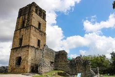 an old stone building with stairs leading up to it and a blue sky in the background