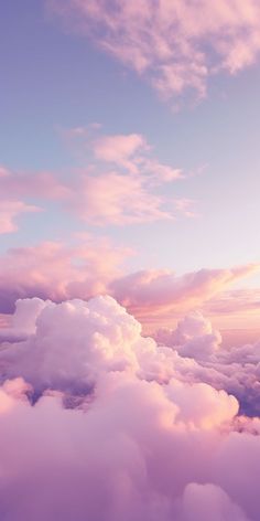 an airplane is flying high above the clouds in the sky at sunset or dawn with pink and blue hues