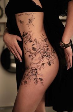 a woman's thigh with flowers on it and the words finene fraen tattoo