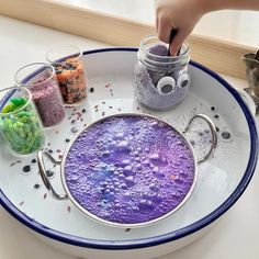 a plate that has some kind of purple substance on it and two jars with different colored stuff in them