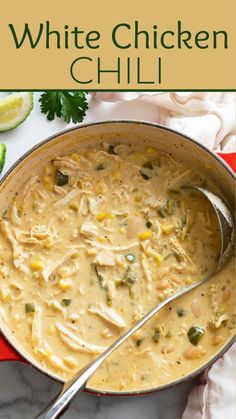 white chicken chili in a red pot with a spoon and cilantro on the side