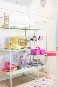 a white shelf filled with lots of toys on top of a rug in a child's room