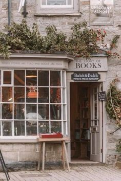 the outside of a book shop with lots of plants growing out of it's windows