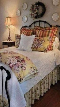 a bedroom with a bed, lamps and pictures on the wall above it's headboard