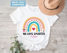 100 Days Smarter, Girls 100th Day Of School Shirt, 100 Days Of School Shirt, Custom 100th Day Of School, Personalized Name 100 Days Rainbow Tee, 100 Days, Celebrate 100th Day, 100 Days Brighter Girls 100th Day of School Shirt! Celebrate this special milestone with our fun and vibrant tee, featuring a colorful "100 Days Smarter" rainbow design. This personalized shirt is perfect for school events, adding a unique touch with your child's name. Let your little one shine in style with this 100 Days Brighter shirt, making the 100th Day of School a memorable celebration! Welcome to BlueRidgeTee  Your Shopping Experience Matters! We value your time and trust, and it's our pleasure to assist you at any point. Have questions? Feel free to reach out! Finding Your Perfect Fit Women's sizes are tailor 100 Days Brighter Shirt, 100 Days Smarter, 100 Days Of School Shirt, Rainbow Tee, 100th Day Of School, Shirt Making, School Events, Rainbow Design, 100 Days Of School