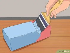 a person is painting the floor with blue and pink paint on top of a cardboard box