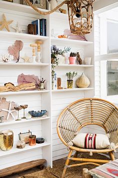 a wicker chair sitting in front of a book shelf filled with books and other items