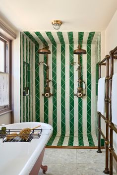 a bathroom with green and white stripes on the shower wall next to a bathtub