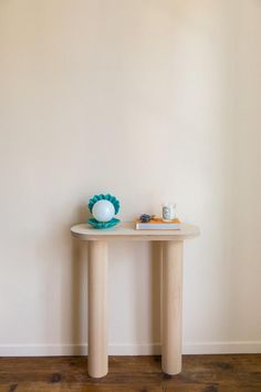 a white table with a blue vase on it