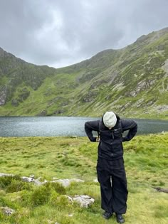 a man standing on top of a lush green hillside