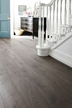 an empty room with wood floors and blue door