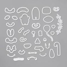 paper cut outs with various shapes and sizes on a gray background, including the words