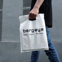 a person walking with a white bag in their hand that says berggy's