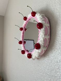 a cake shaped like a heart with cherries on the side and a mirror behind it