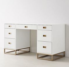 two white desks with gold handles against a white wall