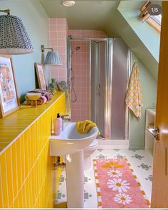 a bathroom with yellow and pink decor on the walls, flooring and shower stall