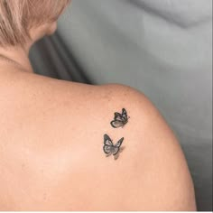 two butterflies on the back of a woman's shoulder