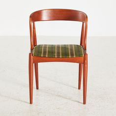 a wooden chair with a green plaid seat pad on the back and armrests