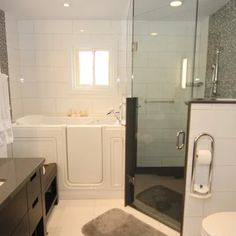 a bathroom with a glass shower door, toilet and bathtub next to a sink