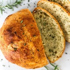 three pieces of bread sitting on top of a white plate next to green sprigs