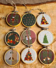 six cross stitch christmas ornament hanging on a piece of wood