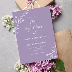 the wedding stationery is surrounded by lilacs and brown envelopes with twine string