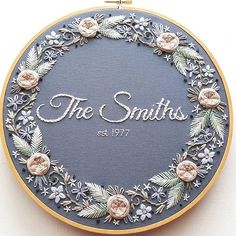 the smiths embroidered logo on a blue and gold hoop with white flowers in it