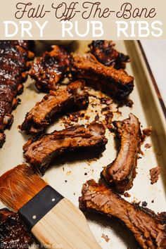 bbq ribs and barbecue sauce on a baking sheet with a spatula next to them