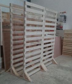 several wooden pallets stacked on top of each other in a room with white walls