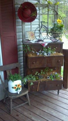 an old dresser is covered with plants on the porch