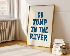 a poster with the words go jump in the river on it next to a stack of books