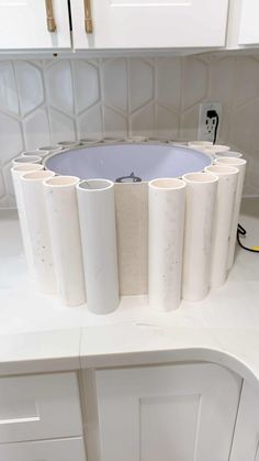 several rolls of toilet paper sitting on top of a counter in a kitchen with white cabinets