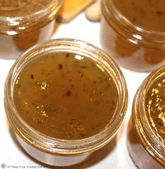 four jars filled with food sitting on top of a white countertop next to each other