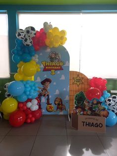 balloons and decorations are on display in front of a window at a children's birthday party