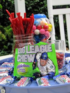 a table topped with candy and candies on top of a blue tray covered in plastic cups