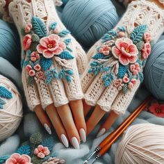 a woman's hands with white nails and flowers on them are holding knitting needles