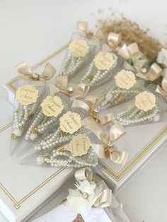 wedding favors with bows and pearls on display for guests to sign the guest's names