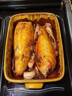 two chicken legs in a yellow dish on the stove