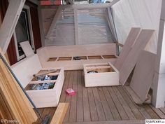 the inside of a house with wooden flooring and storage boxes on top of it