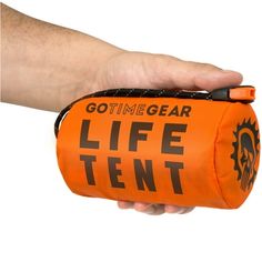 a hand holding an orange life tent in it's right hand, with the words gotimegear on it